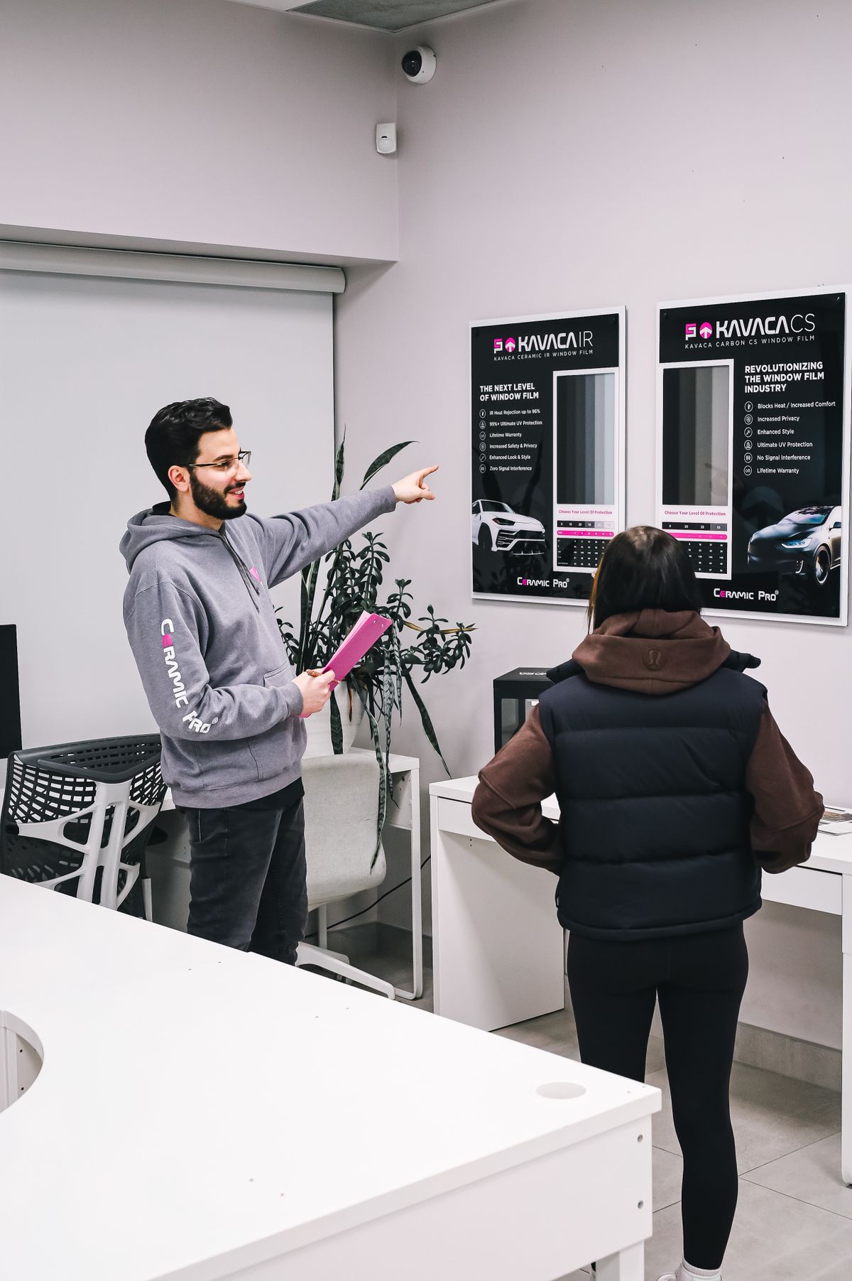 Verkaufsberater erklärt einem Kunden im Autohaus die Fahrzeugausstattung