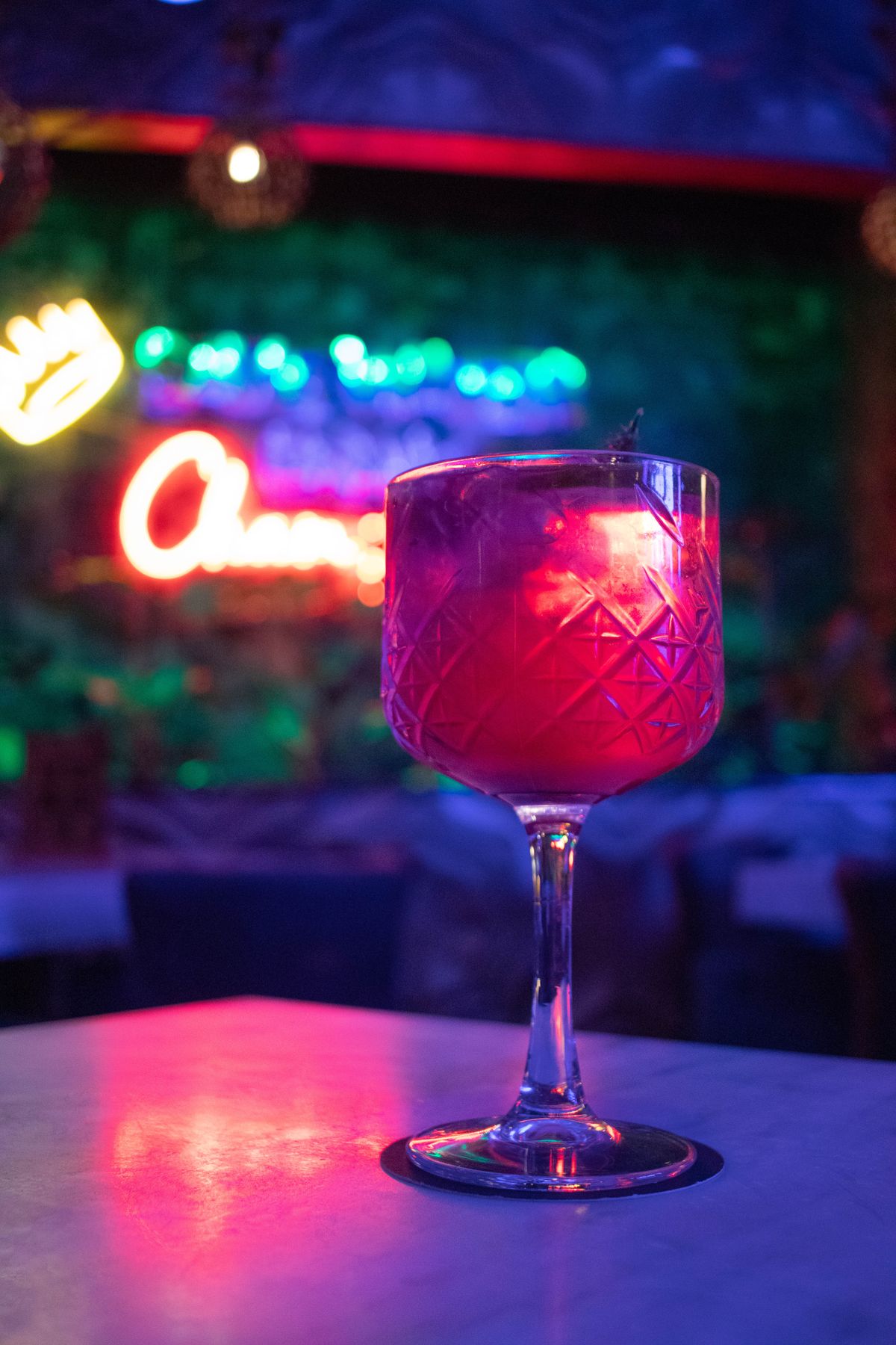 Bunte Cocktails mit Garnitur auf einer Bartheke in stimmungsvollem Licht