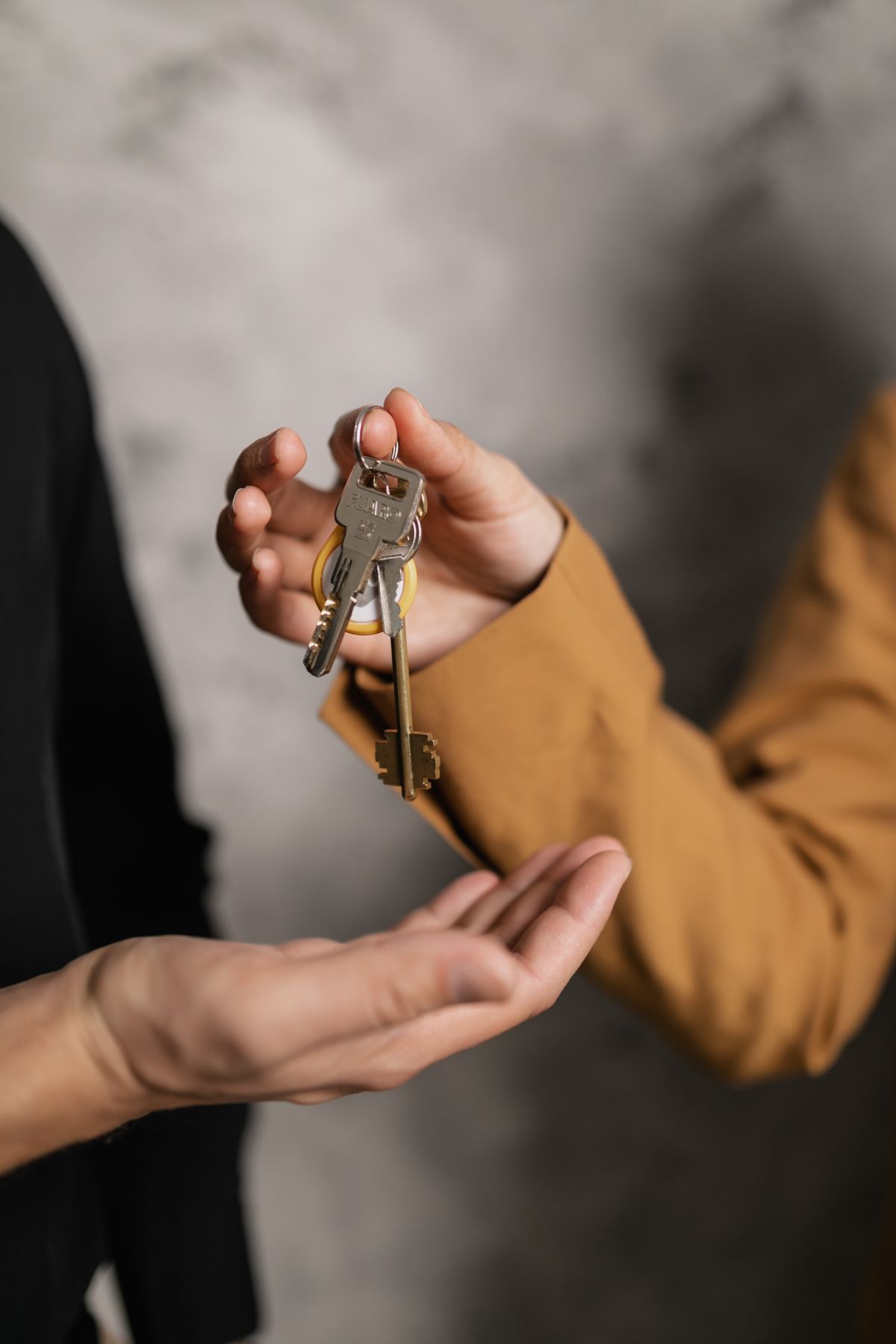 Übergabe der Autoschlüssel zwischen Mitarbeiter und Kunde bei einer Autovermietung