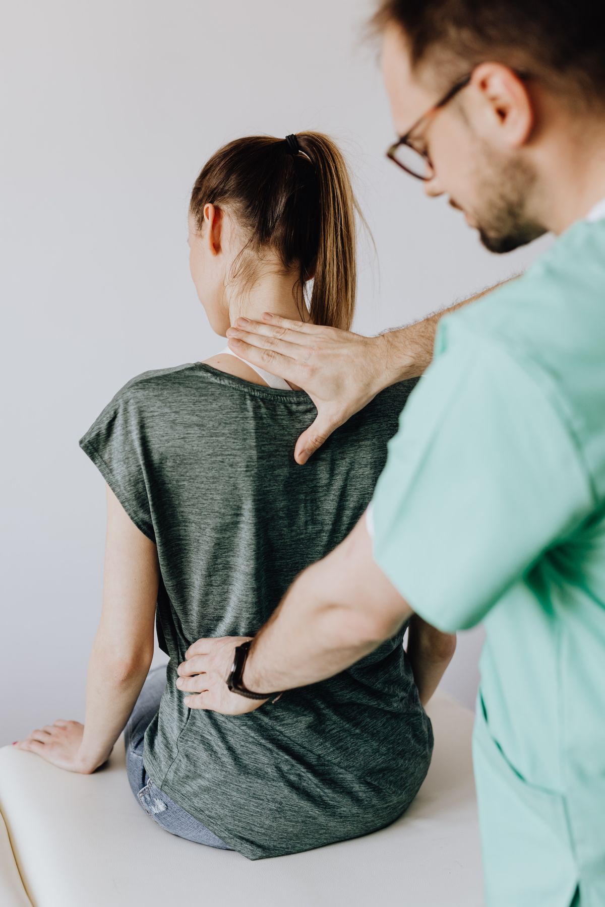 Orthopädische Untersuchung des Rückens einer Patientin in einer Praxis