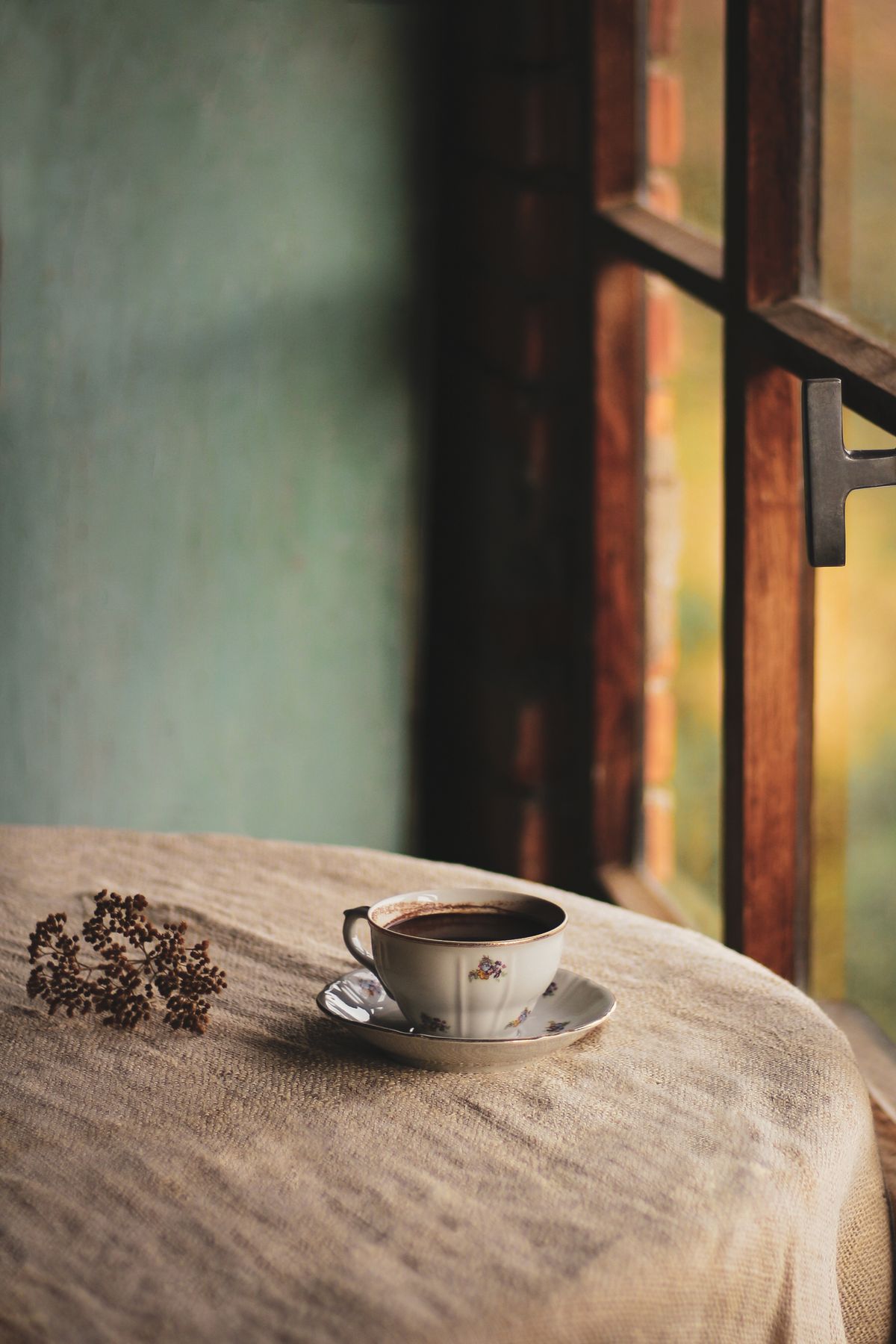 Tasse Kaffee auf einem Holztisch in einem gemütlichen Café mit warmem Licht