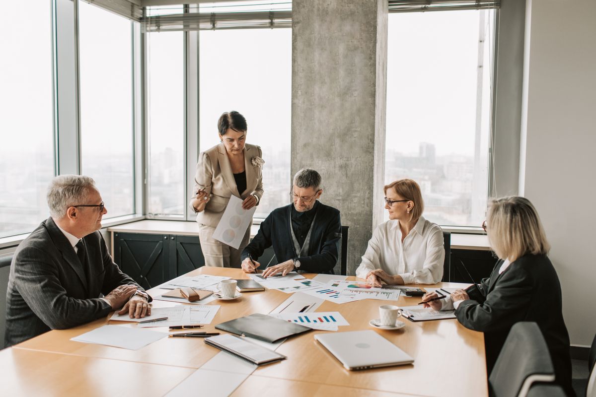 Geschäftspartner besprechen gemeinsam Vertragsunterlagen zur Gewerbeversicherung im Büro