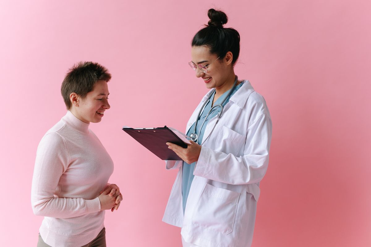 Arzt im Gespräch mit einer Patientin in einer hellen Praxis
