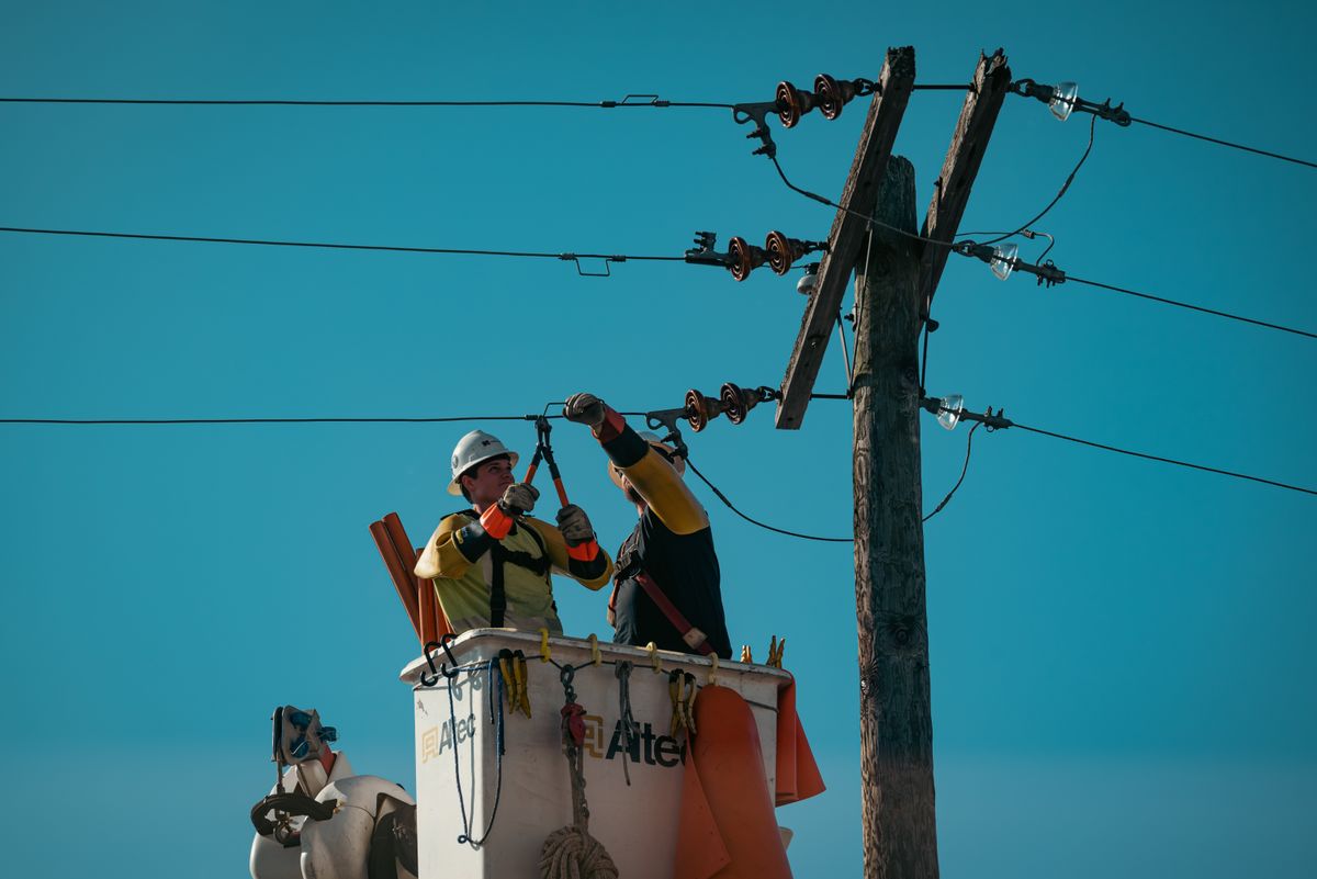 Elektriker in Sicherheitsausrüstung bei Arbeiten an Freileitungen