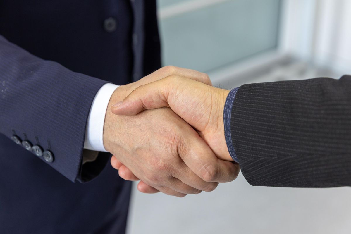 Franchisegeber und Franchisenehmer besiegeln eine Partnerschaft per Handschlag