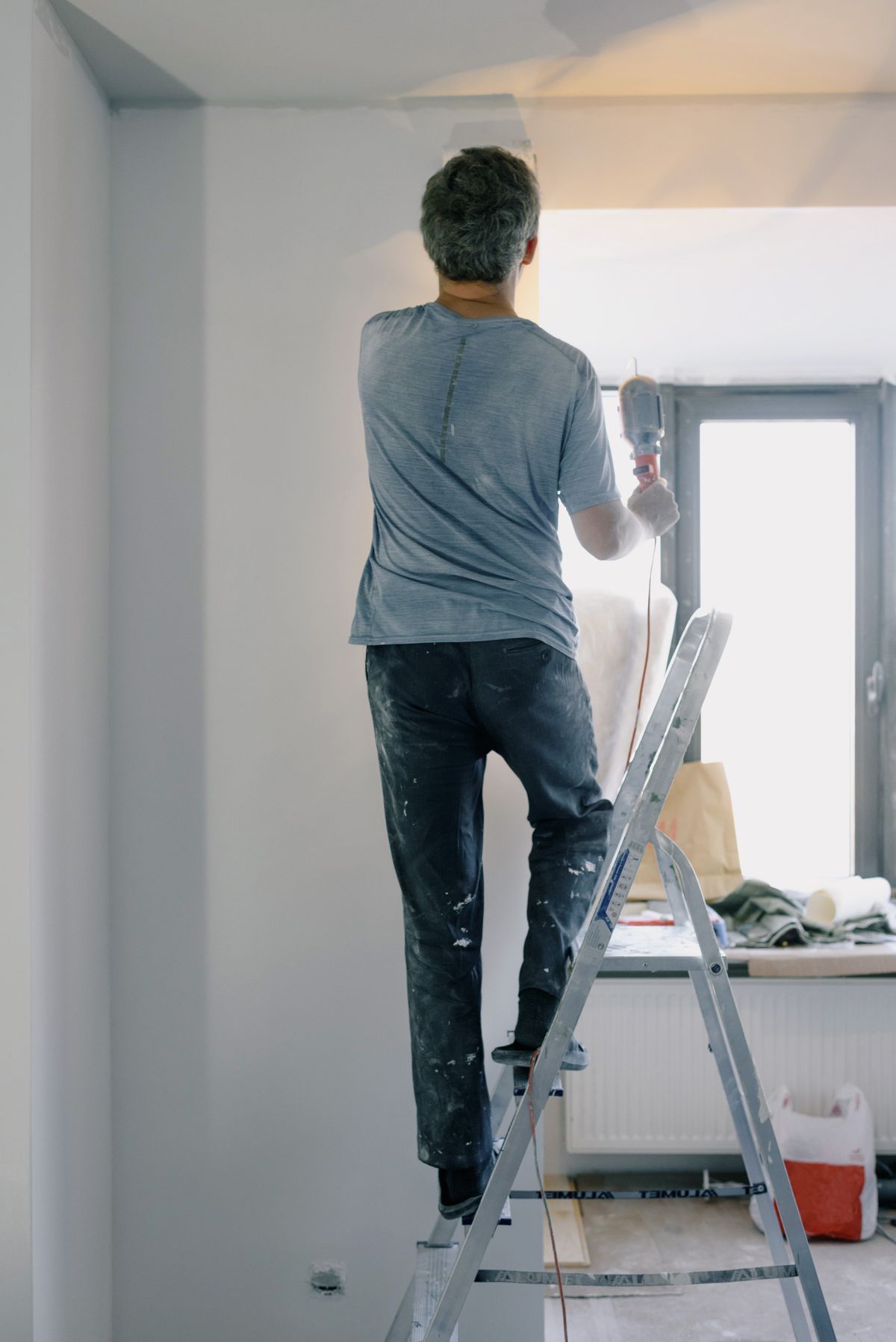 Handwerker mit Werkzeug repariert etwas in einer Wohnung in Hamburg