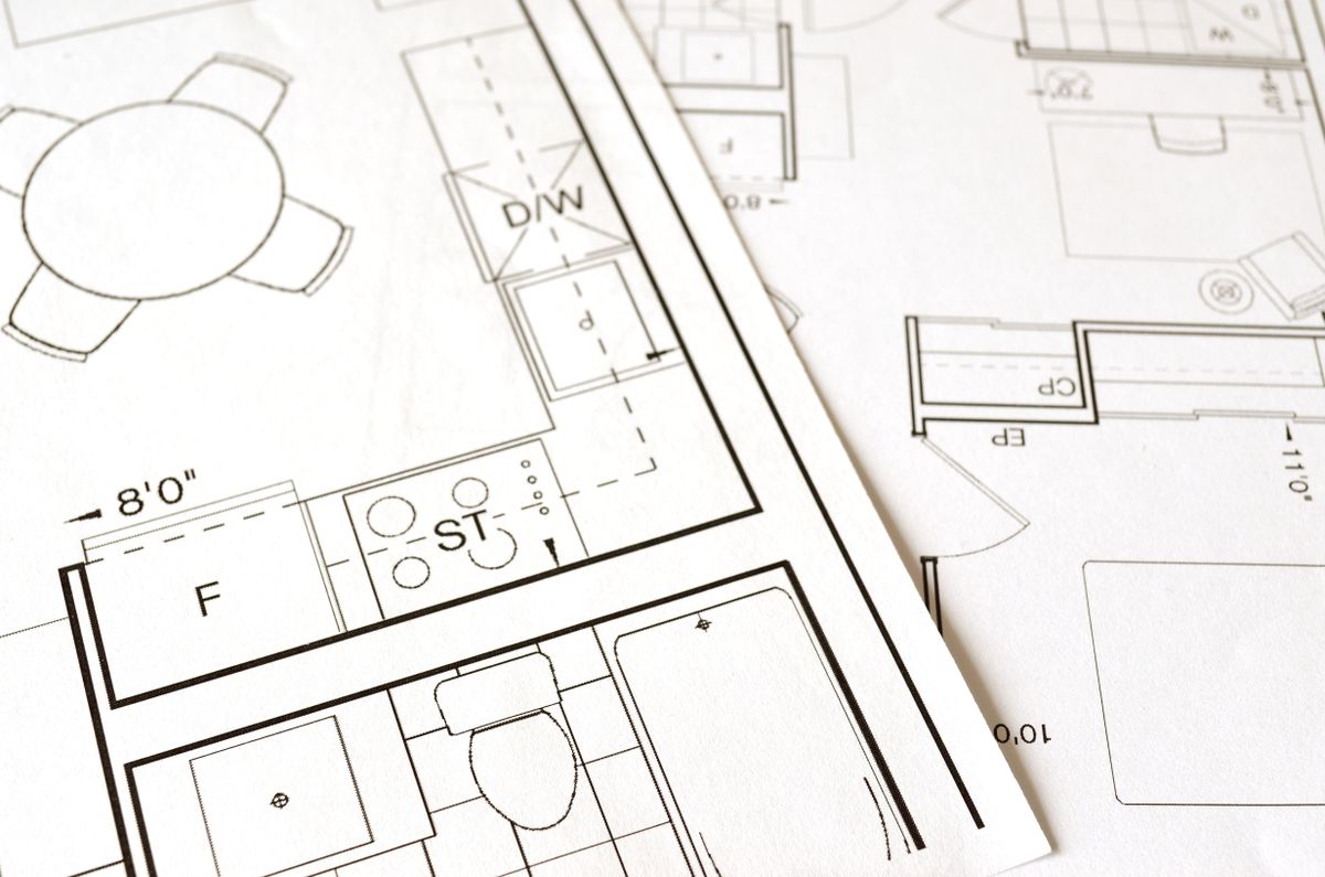 Architektonischer Grundriss und Bauplan eines Einfamilienhauses auf einem Schreibtisch