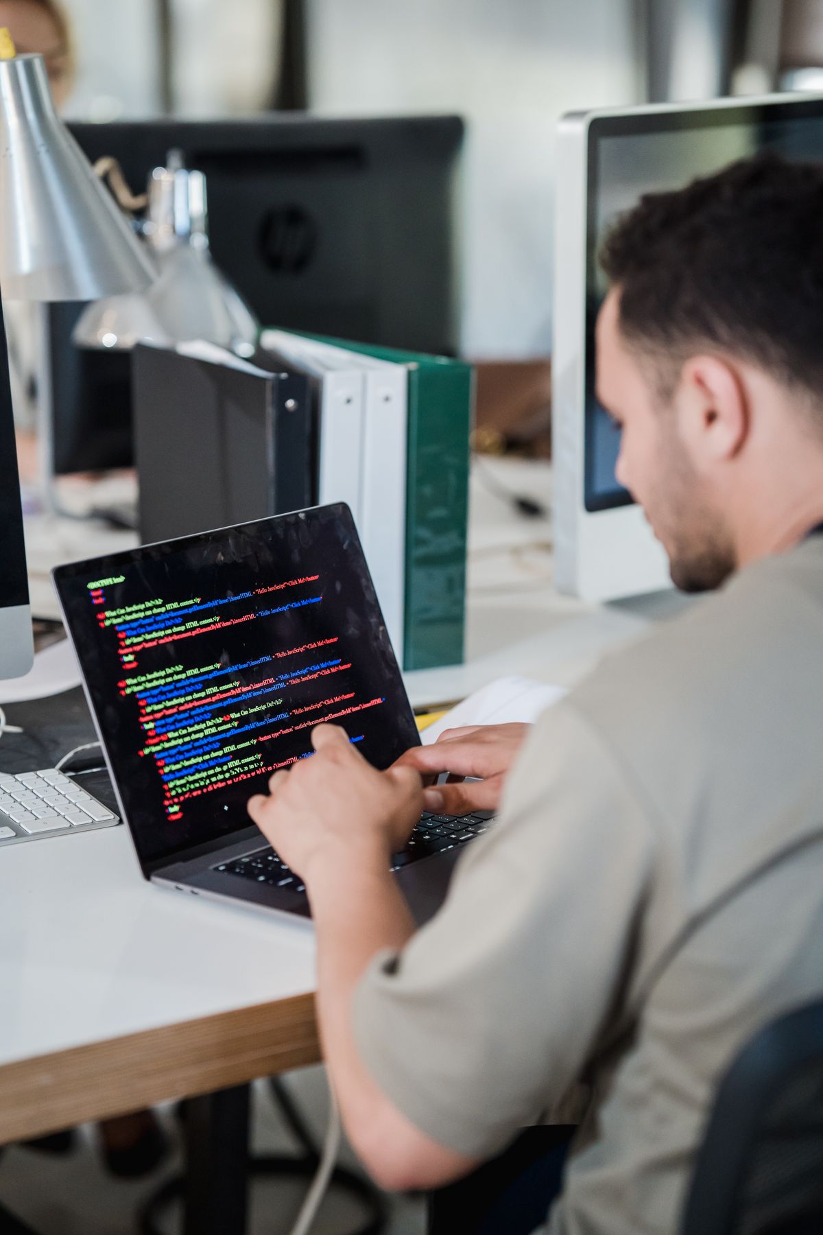 IT-Fachkraft arbeitet konzentriert an einem Notebook im Büro eines IT-Unternehmens