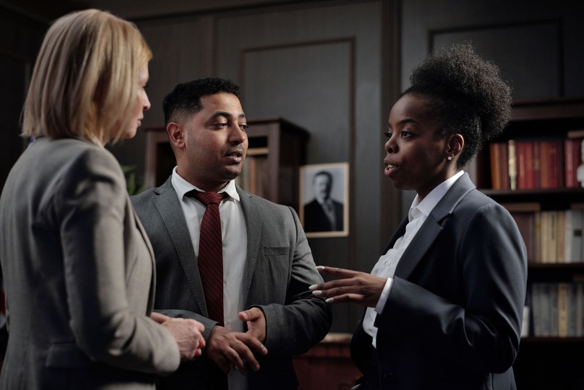 Anwältinnen und Anwälte einer Kanzlei besprechen einen Fall im Büro