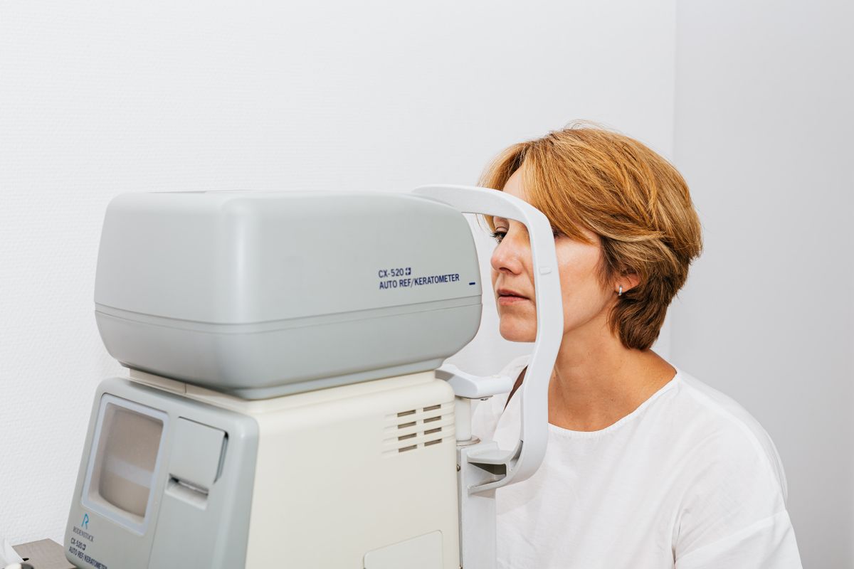 Patientin bei der Sehschärfeprüfung mit modernem Untersuchungsgerät beim Augenarzt