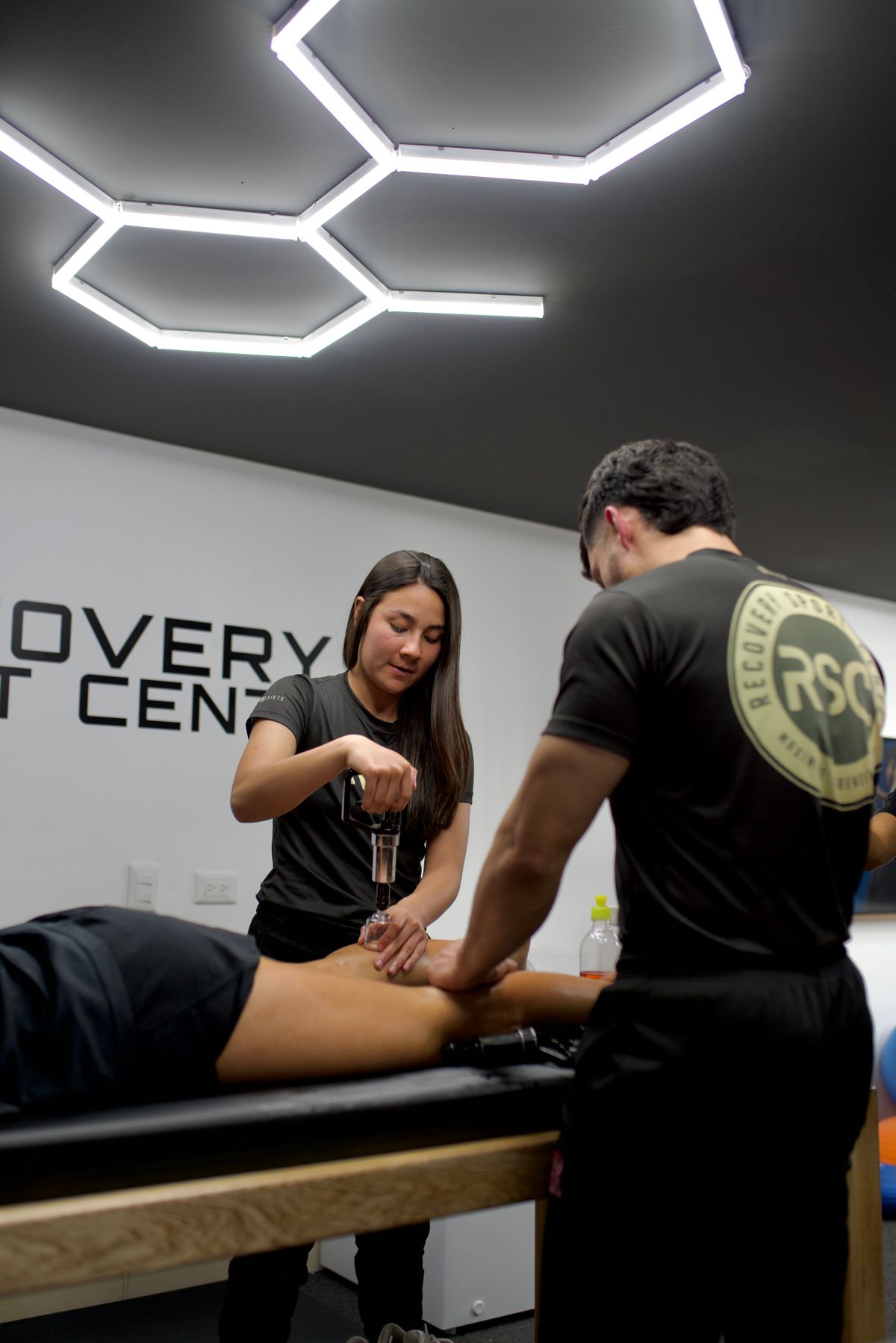 Physiotherapeuten behandeln einen Patienten mit modernen Geräten in einer Praxis