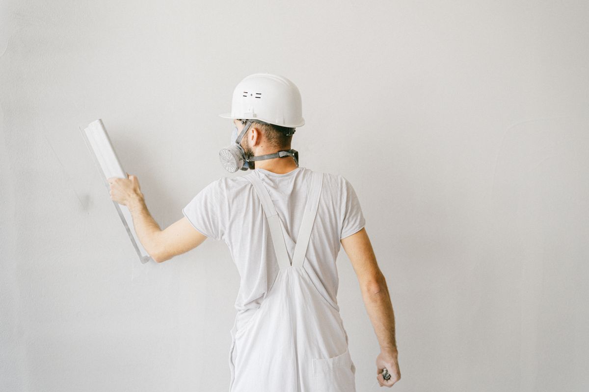 Handwerker verputzt eine Wand während einer Altbausanierung in Hamburg