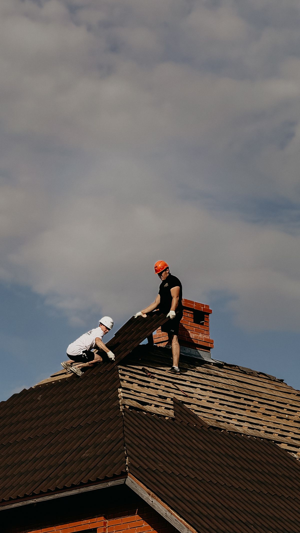 Handwerker repariert ein beschädigtes Dach im Rahmen einer Sanierungsmaßnahme