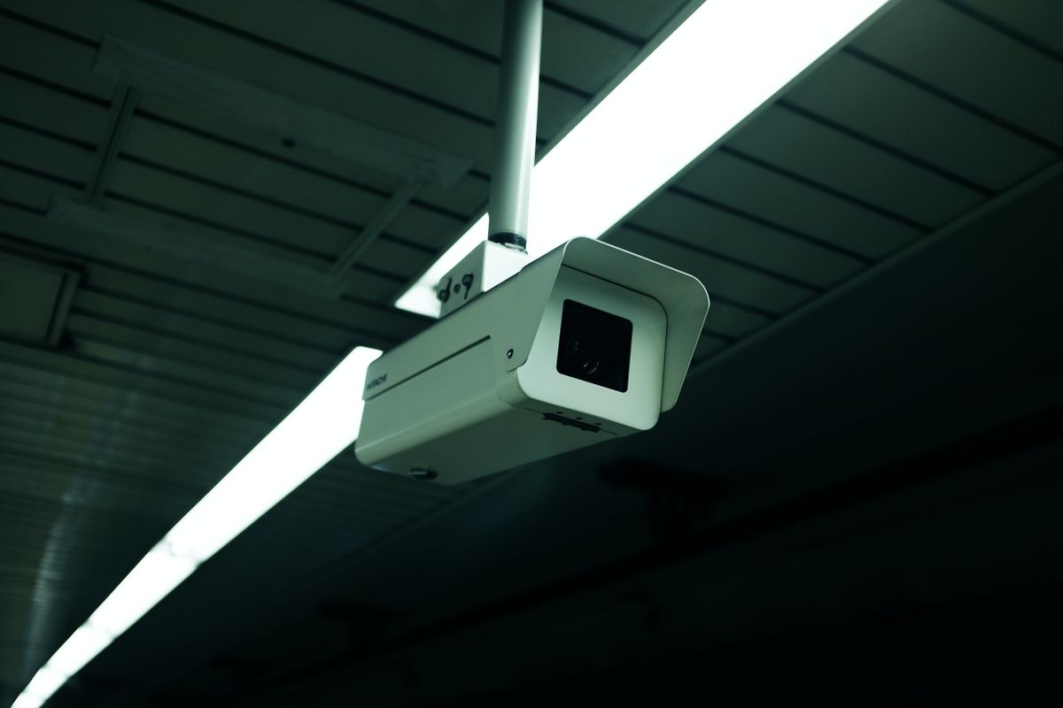 Weiße Überwachungskamera an einer Wand als Symbol für Videoüberwachung und Objektschutz