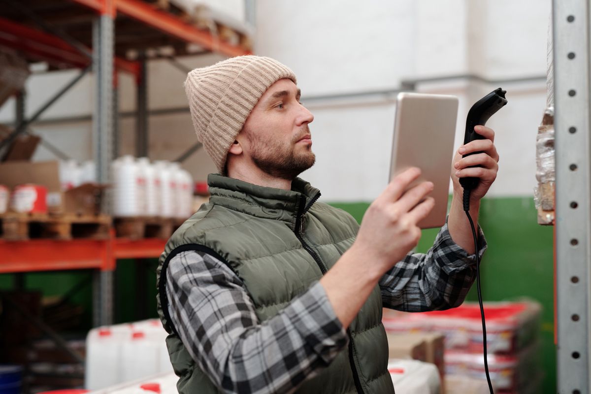 Mitarbeiter im Lager scannt Versandkartons für den Onlineshop-Versand