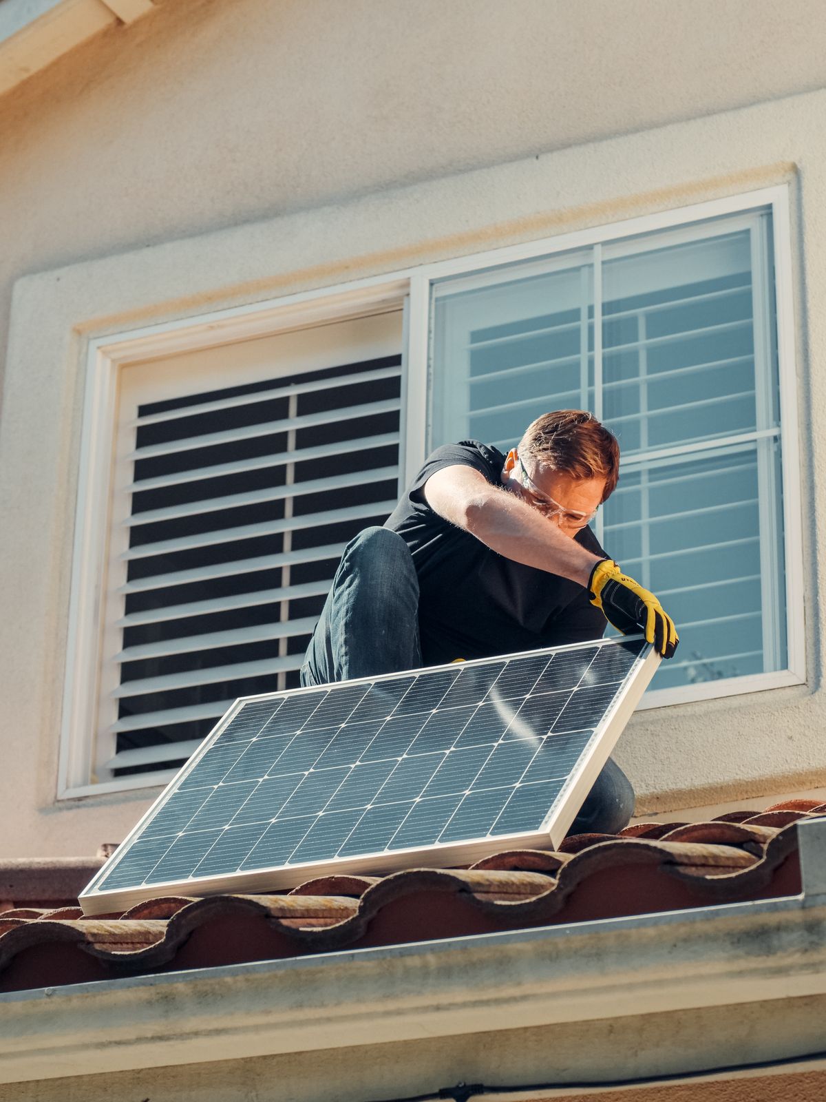 Solarteur installiert ein Photovoltaik-Modul auf einem Hausdach