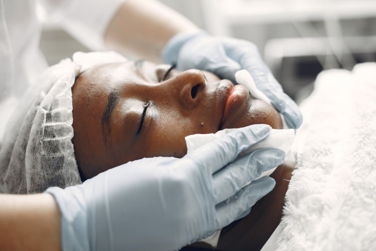 Frau erhält eine entspannende Gesichtsbehandlung in einem Wellnessstudio