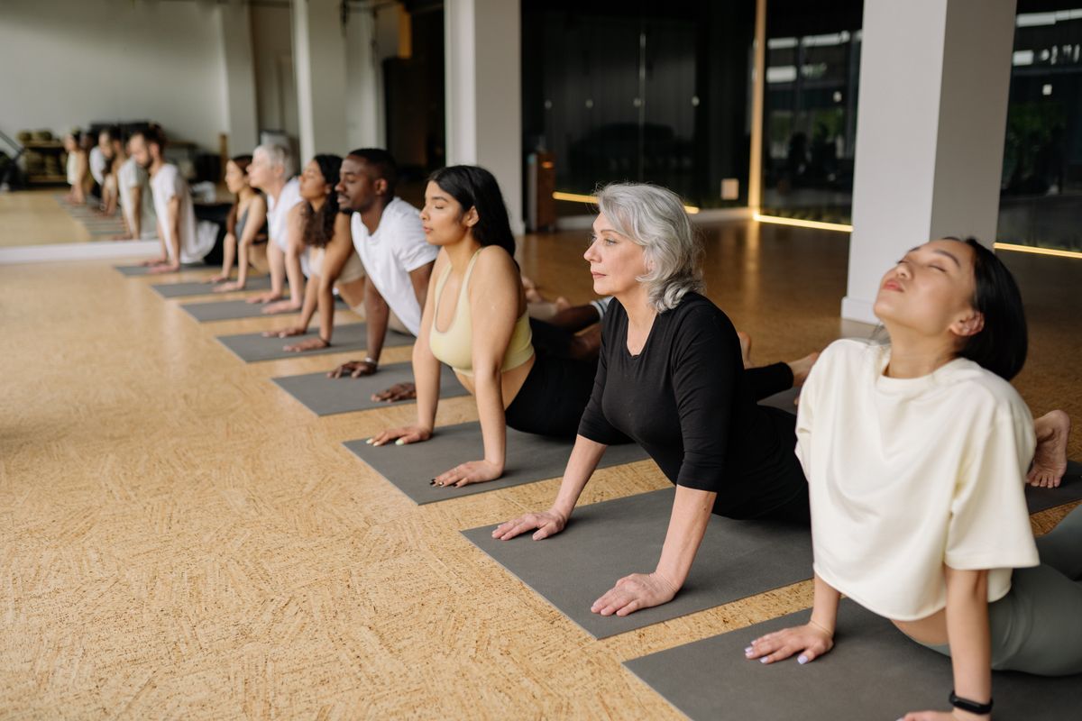 Gruppe von Menschen bei einer Yoga-Stunde in einem hellen Studio